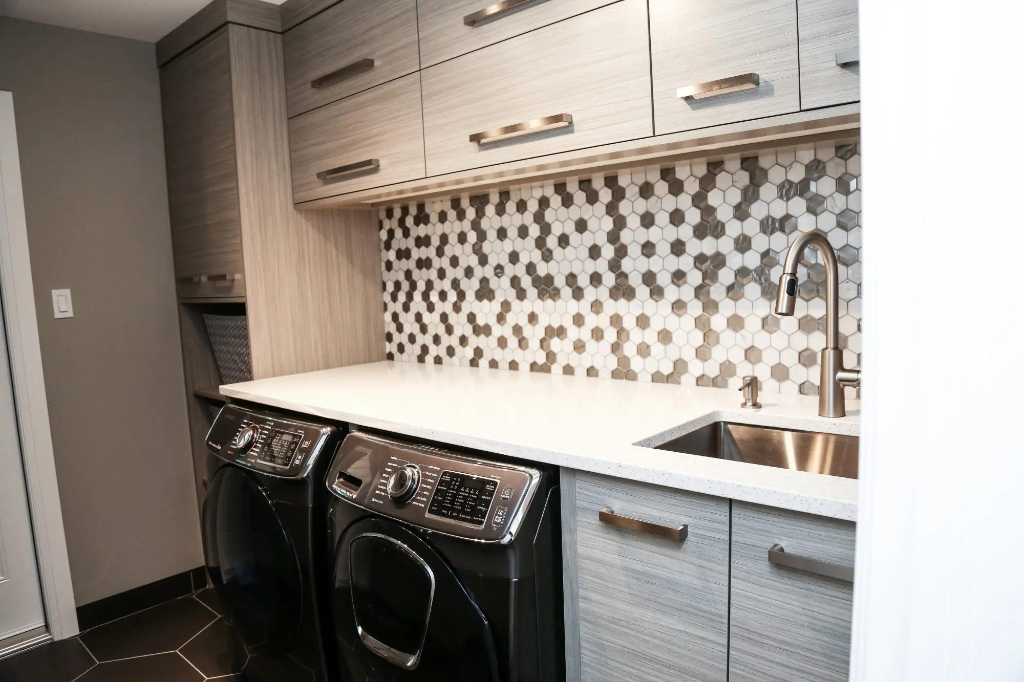 Concrete laundry with pulls cabinetry by Heirlooms Custom Cabinetry